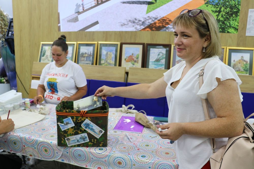 Руководитель агитбригада «Ураган» Александр Краса с гостями нашего стенда пишет письма военным Руководитель агитбригада «Ураган» Александр Краса с гостями нашего стенда пишет письма военным