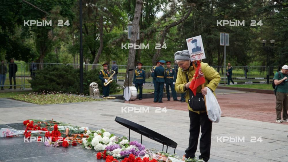В Симферополе люди с портретами своих ветеранов приходят к Вечному огню В Симферополе люди с портретами своих ветеранов приходят к Вечному огню