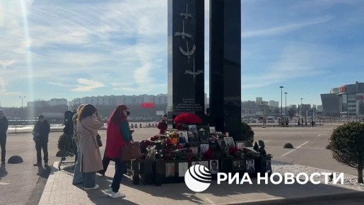 Люди несут цветы к мемориалу в память о жертвах теракта в "Крокус сити холле" в Подмосковье
